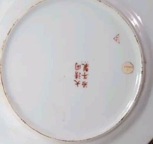 Close view of the red multi-character mark on the underside of the porcelain plate